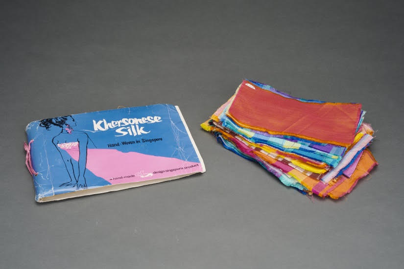 An original fabric swatch book containing the different patterns of Khersonese silk on offer by Design Singapura.