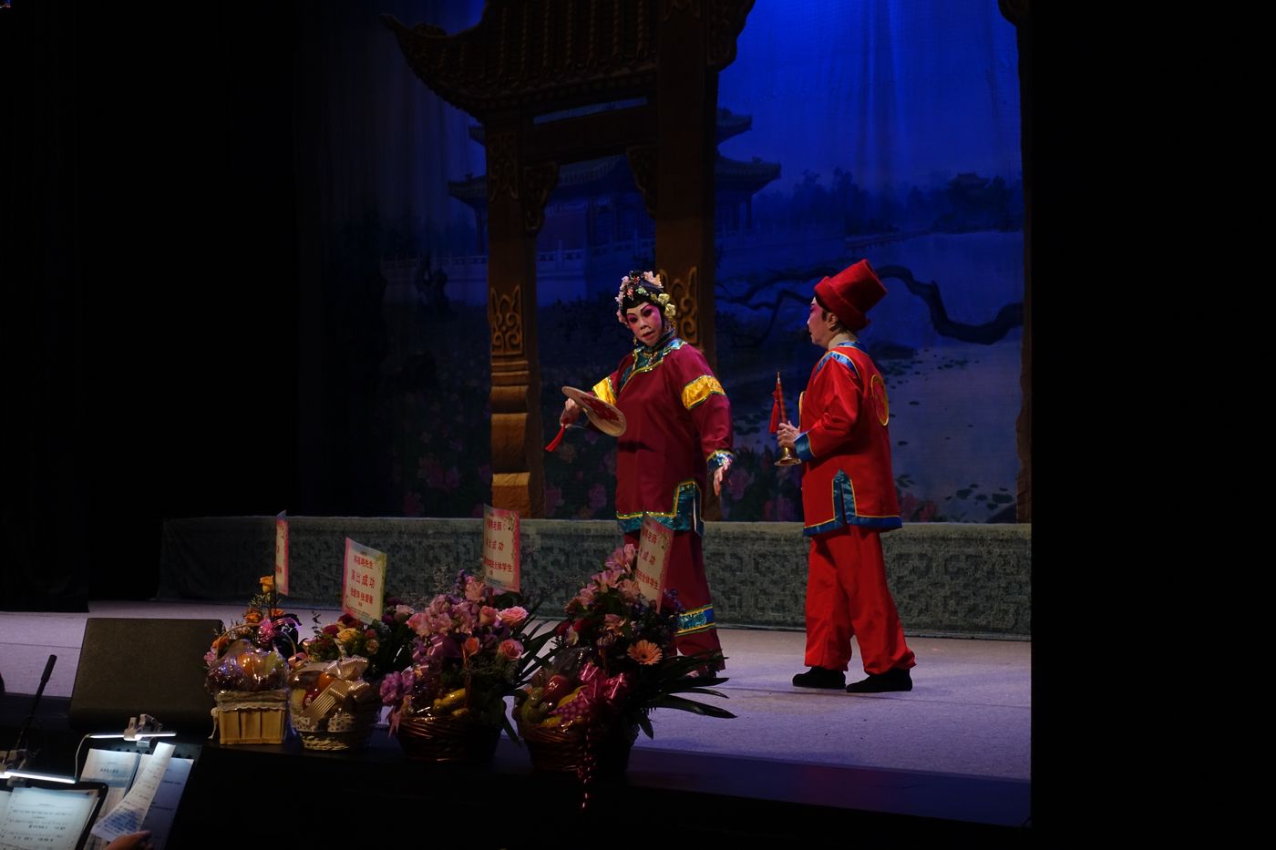 Actors in a Cantonese opera performance, accompanied by musicians.