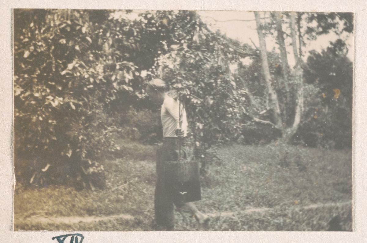 A Chinese labourer at Tanglin Barracks hauling buckets with a