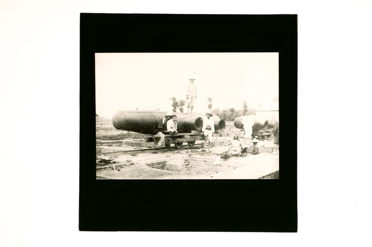 a-glass-lantern-slide-depicting-a-group-of-men-at-a-factory